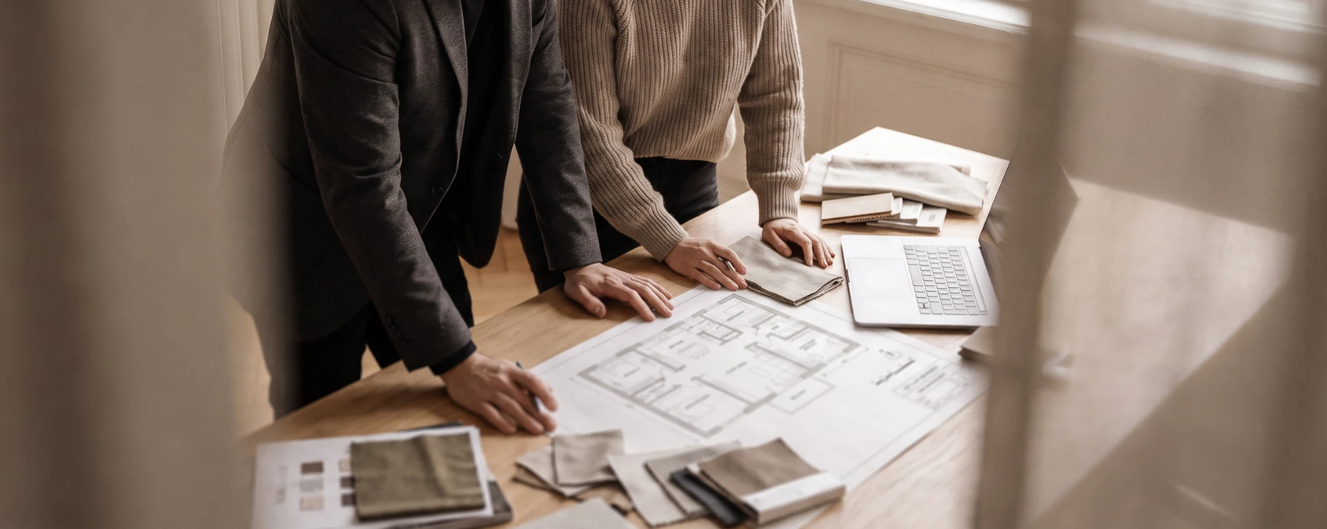 Reviewing floor plans and material samples on a studio table