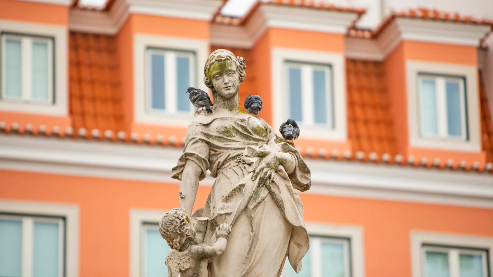 Baroque statue against an orange-washed façade in Lapa